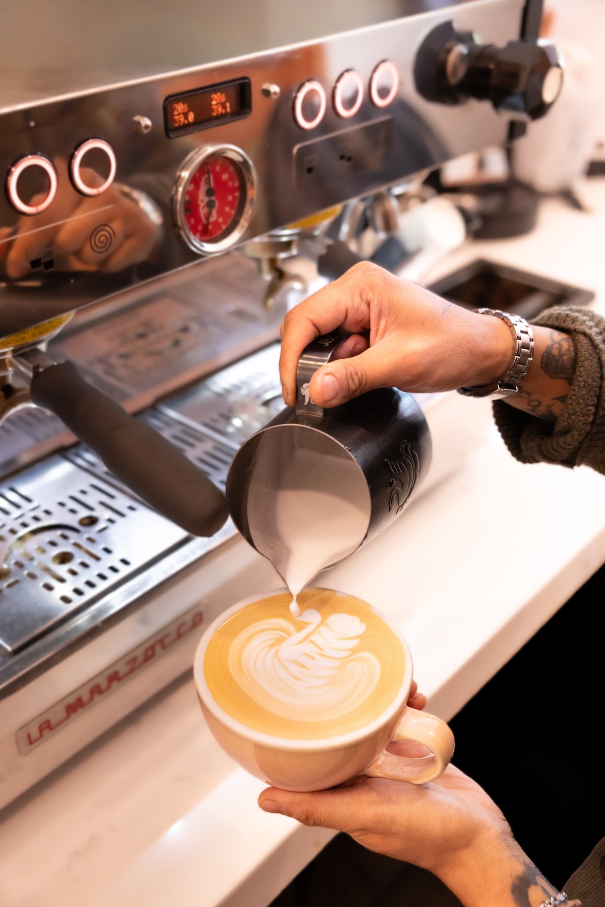Barista pouring milk for latte art